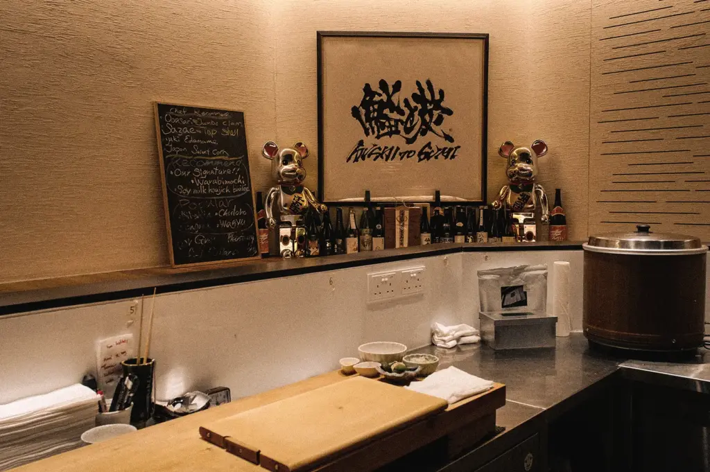 Eye-level wide-angle view of the Sushi To Sumi counter in Singapore, showcasing an intimate Japanese omakase setting inspired by traditional Osaka sushi craftsmanship.