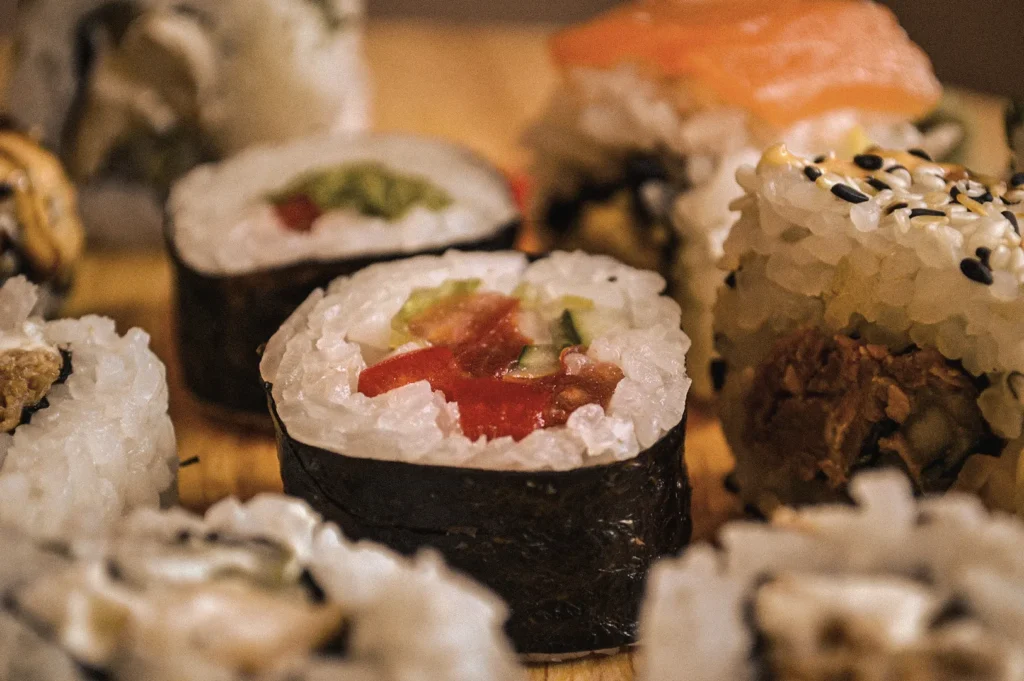 Close-up view of assorted Japanese sushi featuring traditional maki sushi rolls, uramaki, and nigiri, highlighting fresh ingredients, nori-wrapped rice, and authentic sushi craftsmanship.