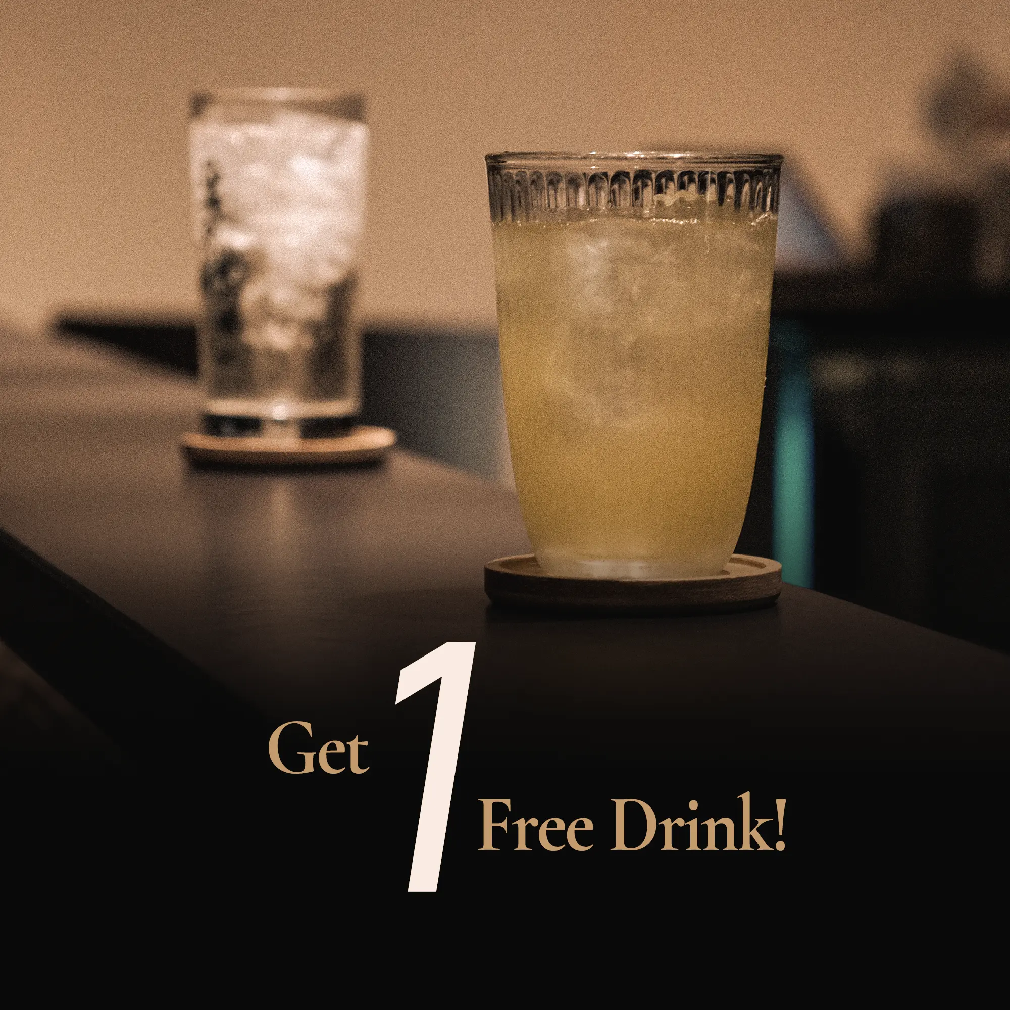 Eye-level close-up shot of a complimentary iced cocktail on a bar counter at a premium Japanese sushi restaurant, featuring a free drink promotion during happy hour with warm ambient lighting and soft background bokeh.